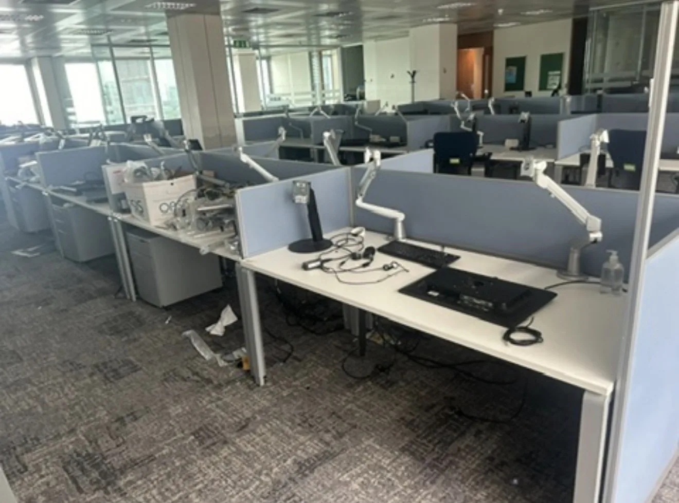 Rows of office desks, monitors and workstation partitions